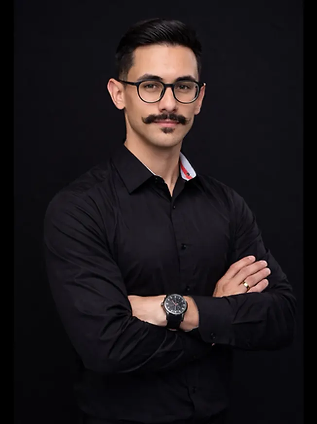 Vitor Guilherme, massoterapeuta em Cascavel, de braços cruzados em retrato profissional